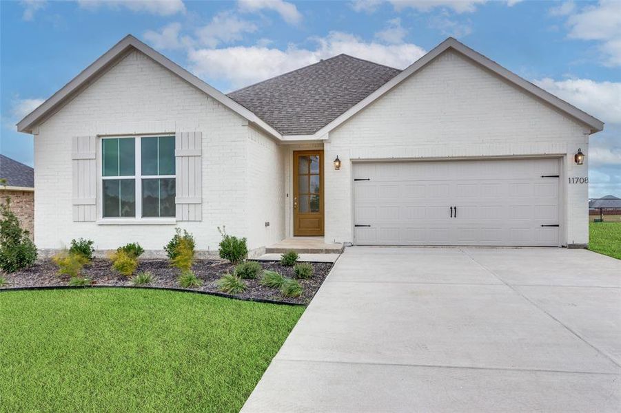 View of front facade featuring a front yard and a garage