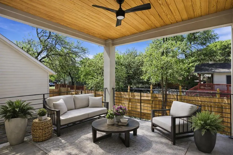 View of patio with an outdoor lounge area and a ceiling fan - virtually staged .