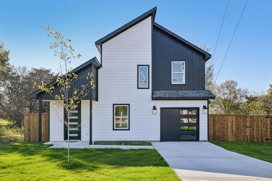 Contemporary house featuring driveway, an attached garage, and a shingled roof