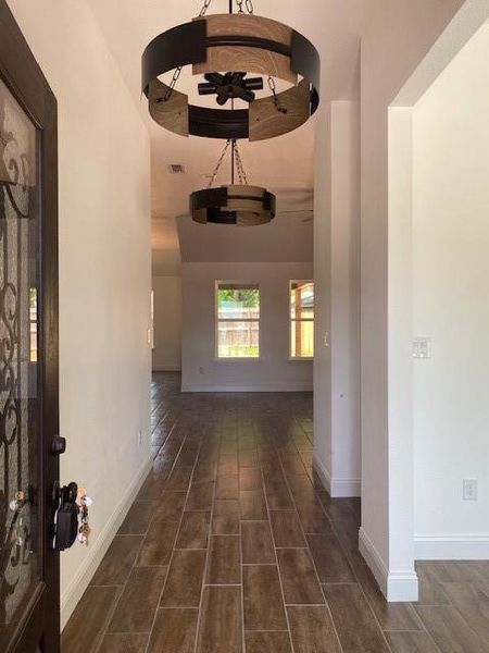 Corridor with visible vents, wood finish floors, and baseboards