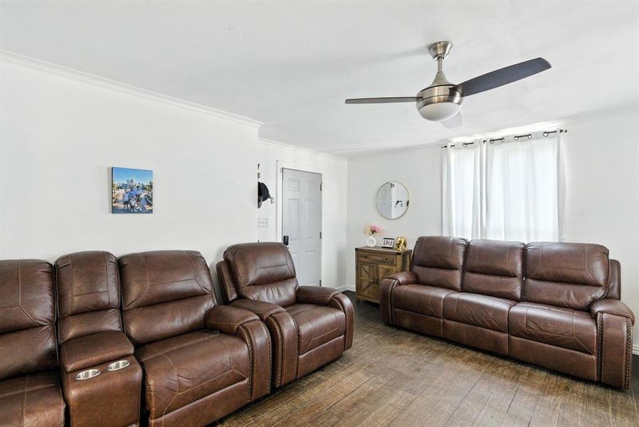 Living room featuring a ceiling fan, crown molding, and wood finished floors