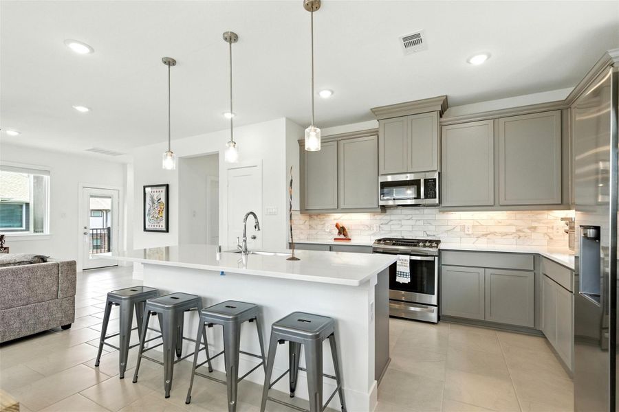 Adorned with a tasteful breakfast bar,the island seamlessly blendspracticality with style, making it theperfect place for quick meals orsocializing while cooking. Adorned with a tasteful breakfast bar,the island seamlessly blendspracticality with style, making it theperfect place for quick meals orsocializing while cooking.