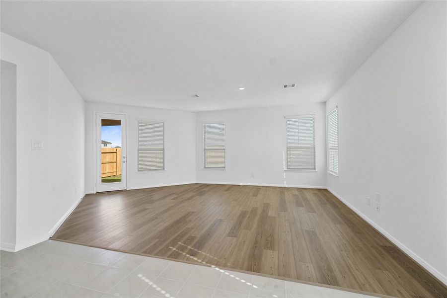 Flooded with natural light from large windows and a patio door, the Great Room feels bright and airy. Recessed lighting adds to the welcoming atmosphere, perfect for gathering with family and guests.