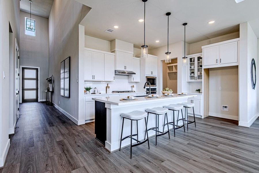 Open-concept kitchen featuring a large island, pendant lighting, and bar seating