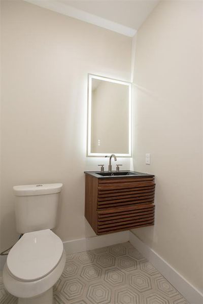 Bathroom featuring tile patterned flooring, vanity, and toilet