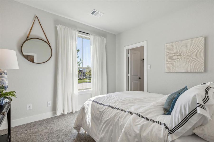 Carpeted bedroom with multiple windows