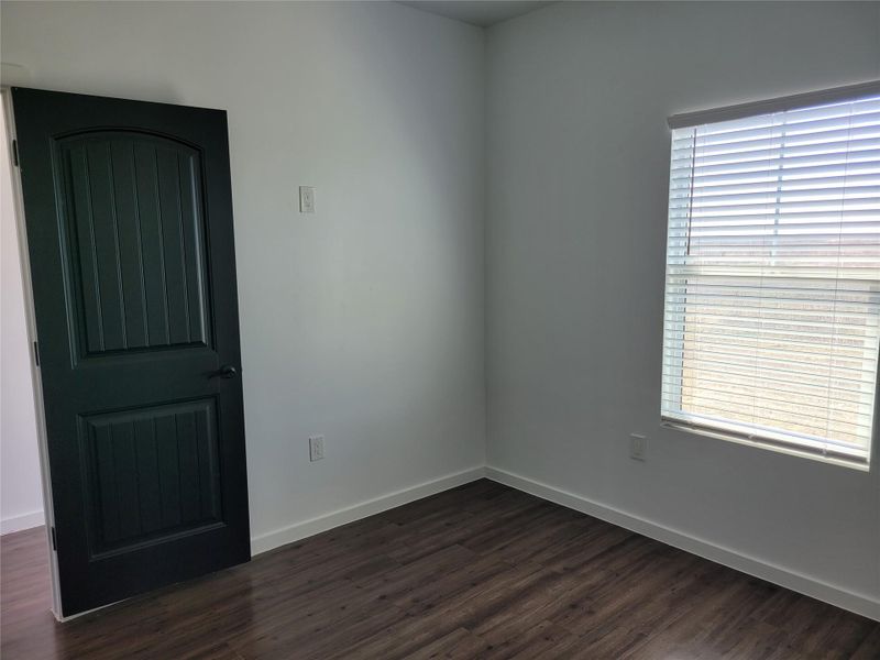 Spare room with dark wood finished floors and baseboards
