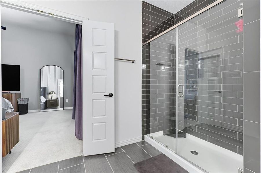 Bathroom featuring a stall shower and baseboards