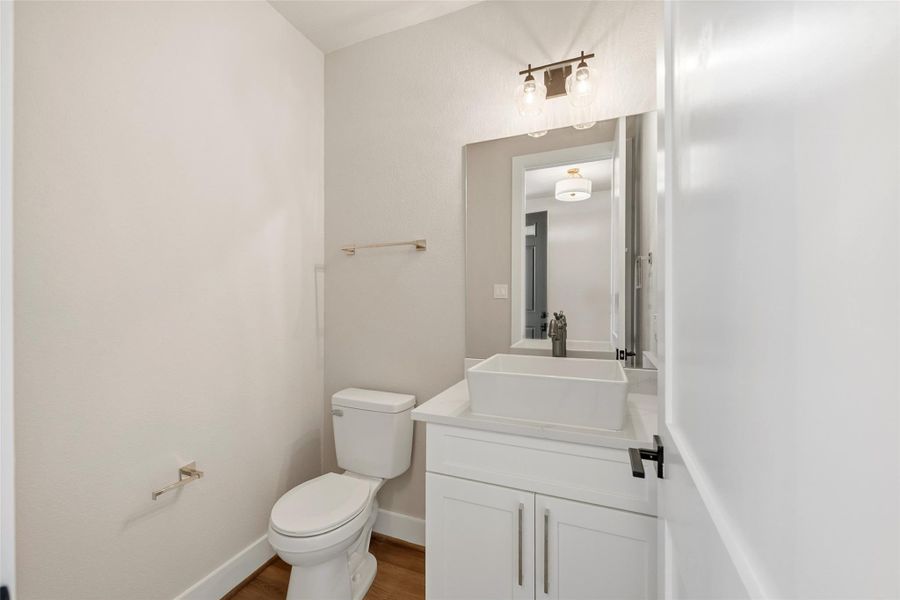 Modern, bright bathroom with a white vanity, vessel sink, and a sleek mirror. It features contemporary lighting, creating a fresh and inviting space.