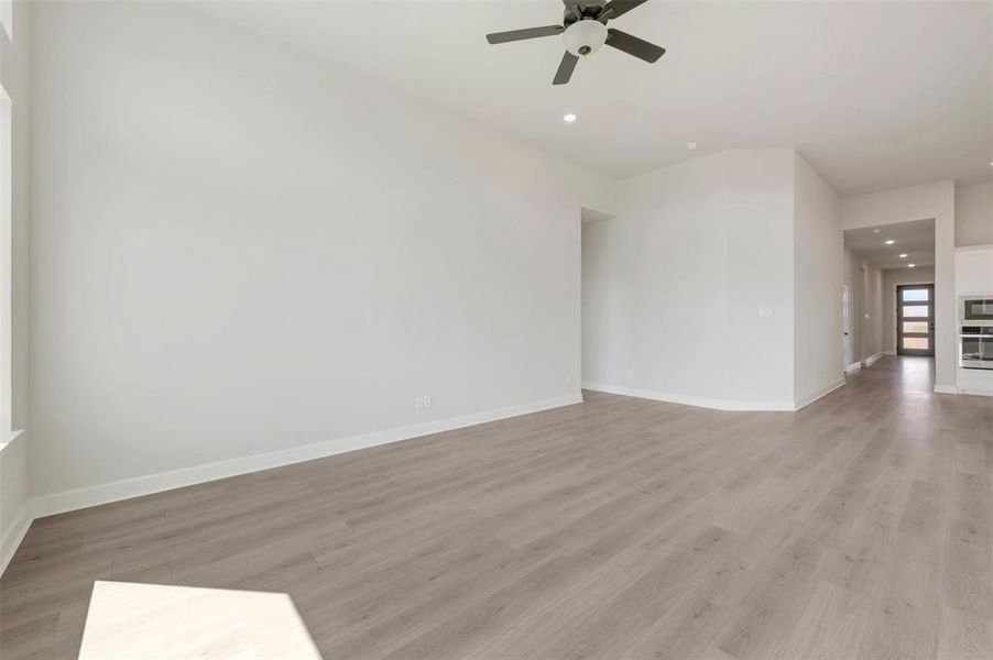 Open-concept living area featuring wood-finish flooring, recessed lighting, and a ceiling fan