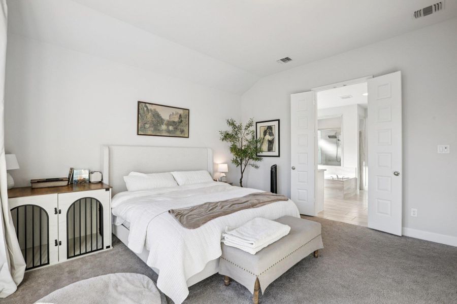 Bedroom with carpet floors and lofted ceiling