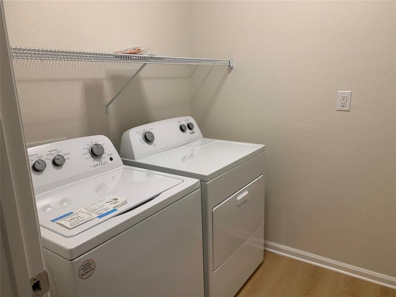 Washroom with light wood finished floors and independent washer and dryer