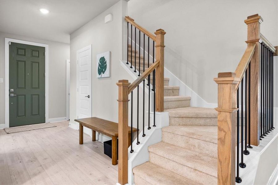 Foyer entrance with wood finished floors, stairway, and recessed lighting Foyer entrance with wood finished floors, stairway, and recessed lighting