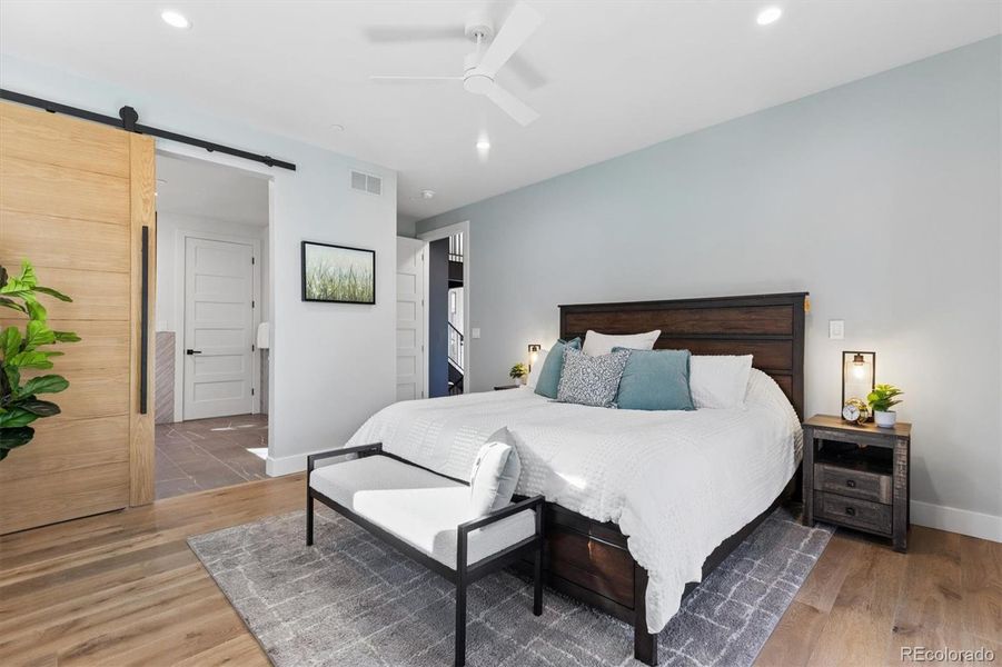 Primary bedroom suite with barn door to Spa inspired 5-piece bathroom and walk in closet Primary bedroom suite with barn door to Spa inspired 5-piece bathroom and walk in closet