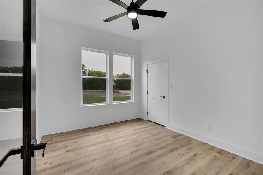 Empty room with light hardwood / wood-style flooring and ceiling fan