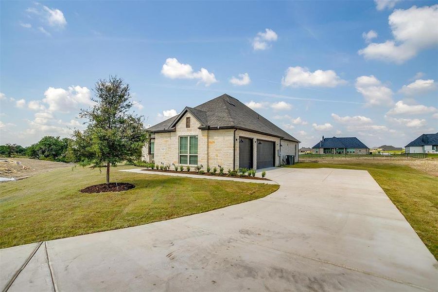 French country inspired facade with a garage and a front lawn