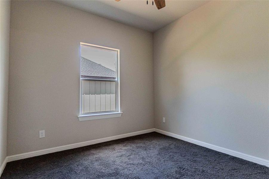 Unfurnished room featuring carpet floors and ceiling fan