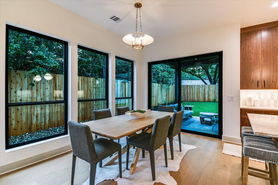 A refined dining space with abundant natural lighting offers direct views of the private backyard. A refined dining space with abundant natural lighting offers direct views of the private backyard.