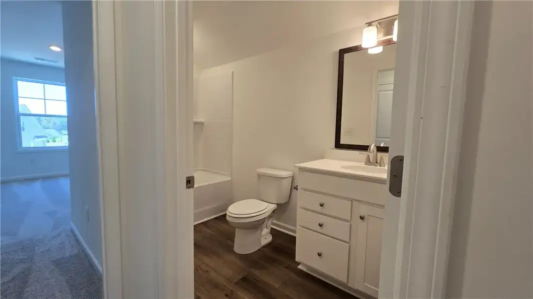 A classic vanity, clean design, and rich wood floo