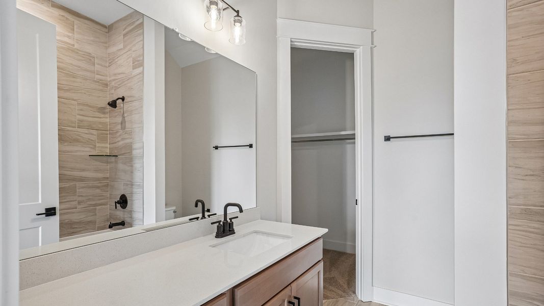 Guest bathroom with tile flooring and shower and walk-in closet