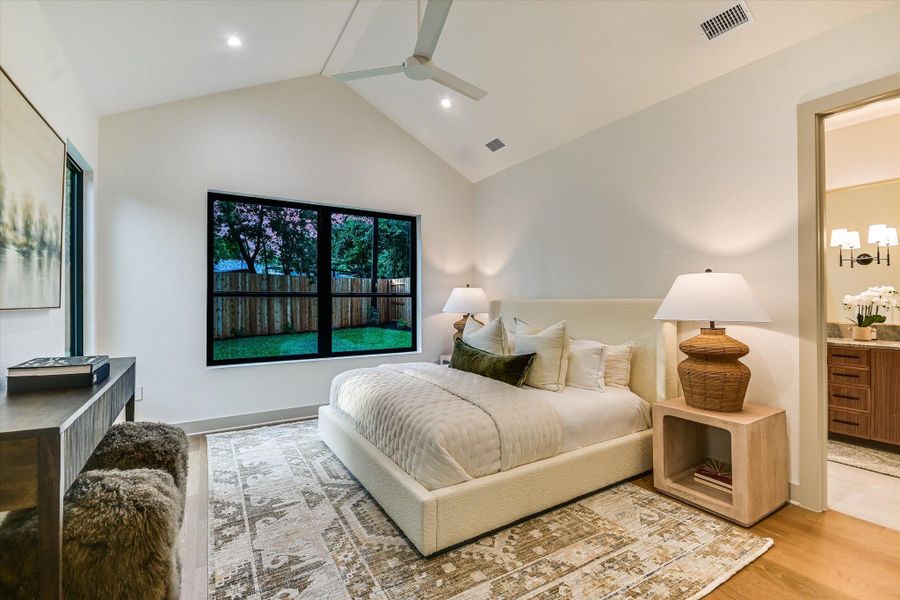 The primary bedroom with vaulted ceilings, recessed lighting, and ceiling fan, & has its own door to the back patio and yard. The primary bedroom with vaulted ceilings, recessed lighting, and ceiling fan, & has its own door to the back patio and yard.