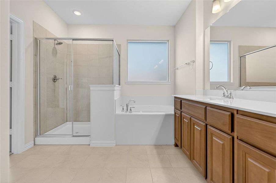 Bathroom featuring vanity, a garden tub, a shower stall, and light tile patterned flooring