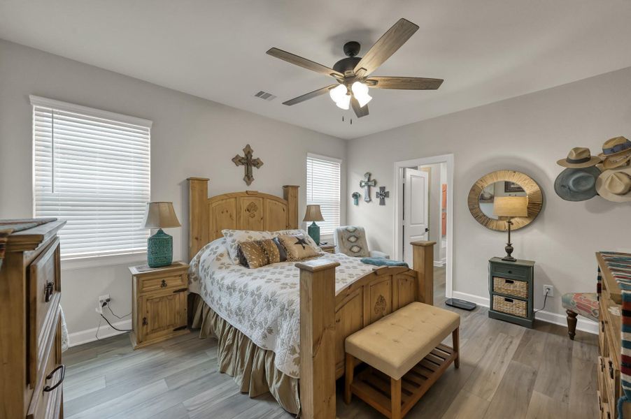 Spacious owner's retreat featuring luxury vinyl plank flooring, abundant natural light, ceiling fan, and a private layout with direct access to the ensuite bath. Spacious owner's retreat featuring luxury vinyl plank flooring, abundant natural light, ceiling fan, and a private layout with direct access to the ensuite bath.