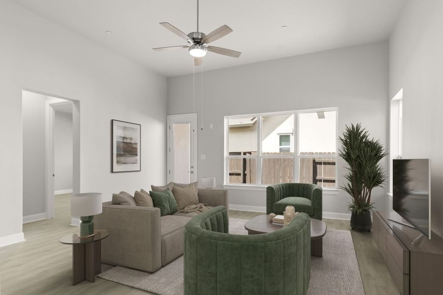 Image of interior living room staging with modern brown and green sofa and chair, a rug, brown coffee table, TV stand and a TV.