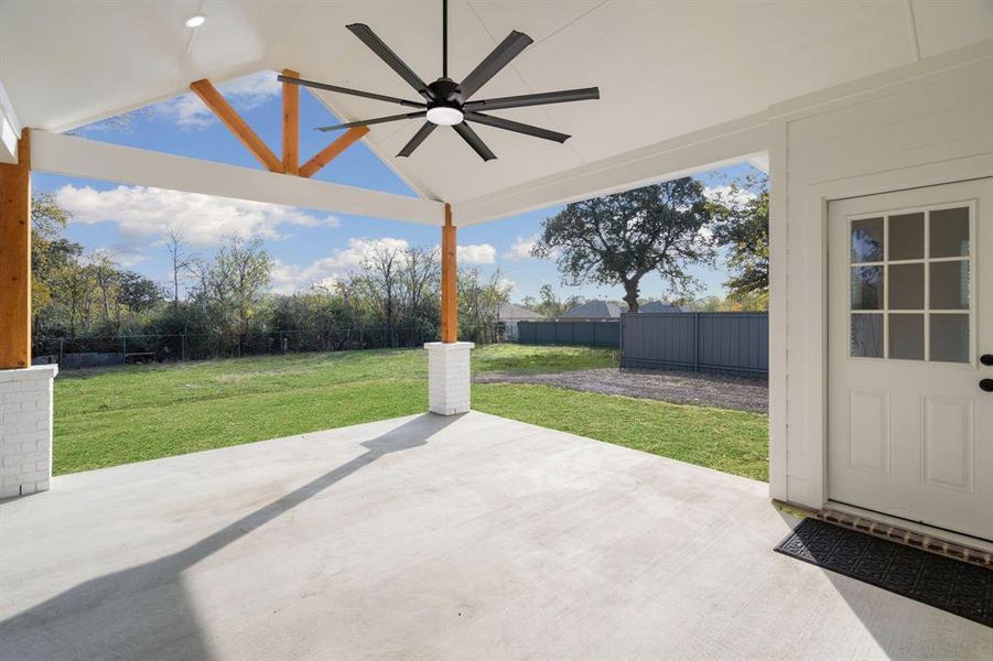 Fenced backyard featuring a ceiling fan and a patio area