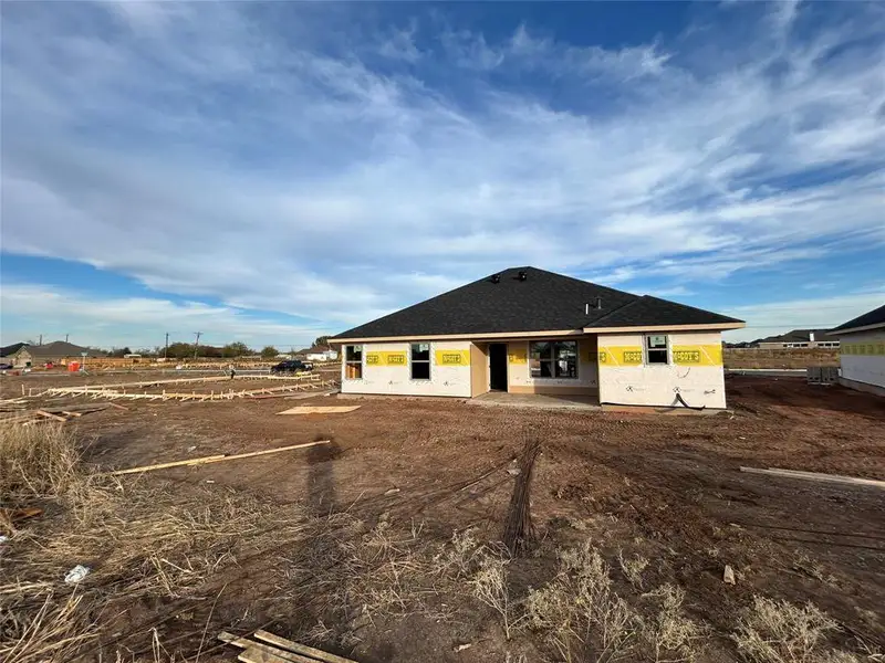 Rear view of property featuring a patio area and a shingled roof