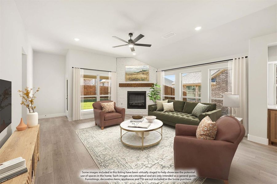 Living room with white brick fireplace, hardwood floors, ceiling fan, and large windows Living room with white brick fireplace, hardwood floors, ceiling fan, and large windows