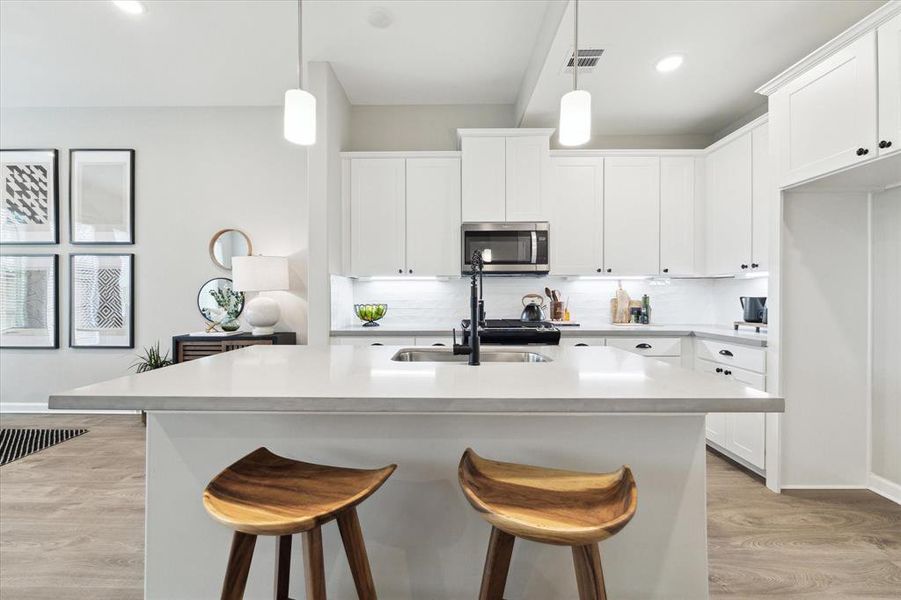 The expansive kitchen island provides ample space for comfortable seating, making it perfect for casual meals or entertaining guests.