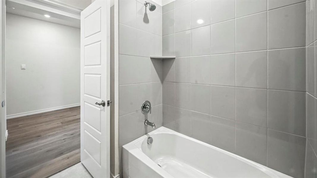 Full bath featuring shower / bath combination, recessed lighting, and wood finished floors Full bath featuring shower / bath combination, recessed lighting, and wood finished floors