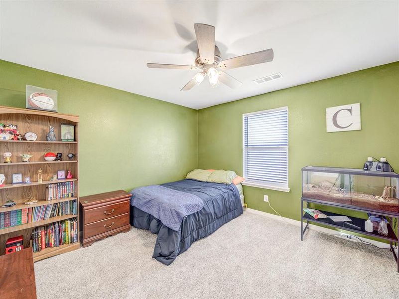 Carpeted bedroom featuring a ceiling fan and baseboards