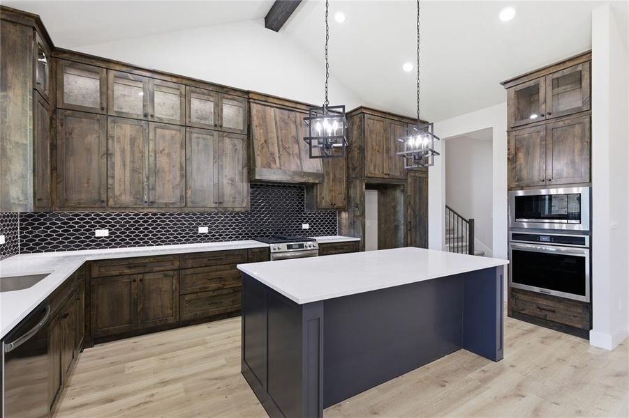 Kitchen featuring a central island, dark wood-finish cabinetry, light wood-finish flooring, a herringbone mosaic tile backsplash, and stainless steel appliances