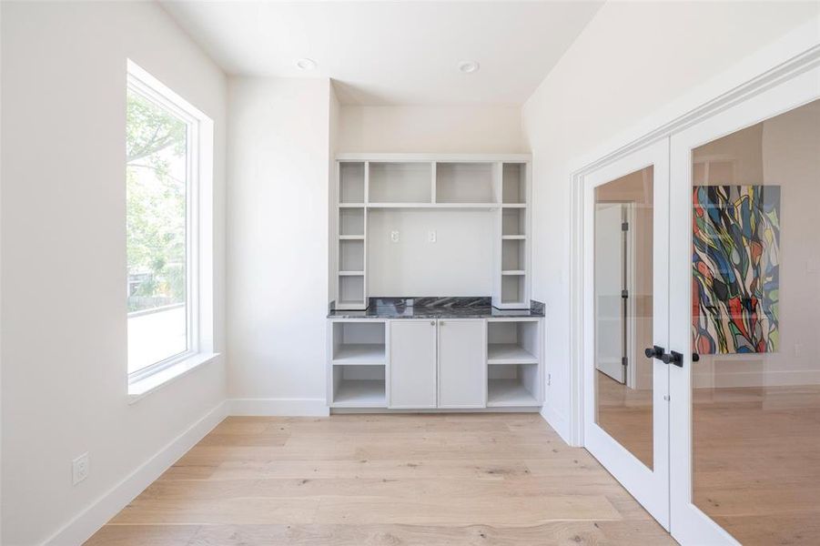 Unfurnished office with light wood-type flooring and french doors Unfurnished office with light wood-type flooring and french doors