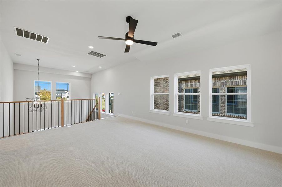 Empty room featuring carpet, a ceiling fan, recessed lighting, and a chandelier