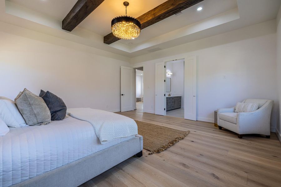 Additional photo of the primary bedroom retreat with warm finishes and generous layout.