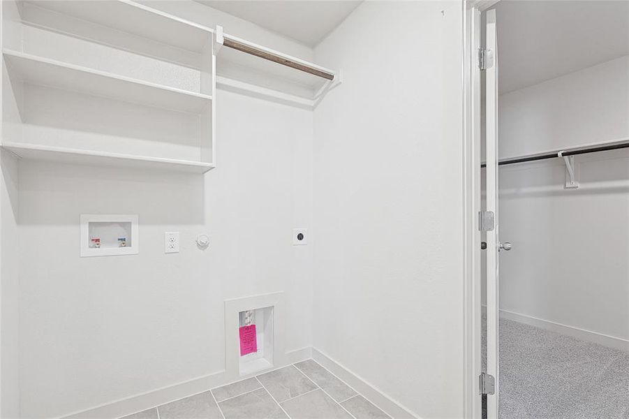 Laundry area featuring hookup for an electric dryer, washer hookup, gas dryer hookup, and light tile patterned flooring