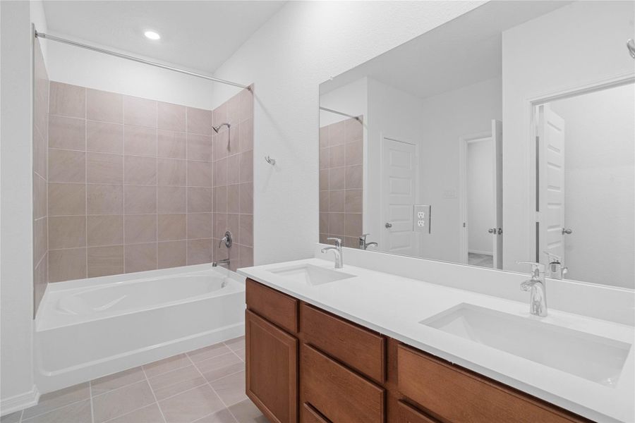 This beautifully updated primary bathroom is move-in ready! It showcases stained cabinetry paired with light countertops, dual sinks, a large mirror, a spacious tub/shower combination with tile surround, high ceilings, custom paint, and stylish modern finishes throughout. This beautifully updated primary bathroom is move-in ready! It showcases stained cabinetry paired with light countertops, dual sinks, a large mirror, a spacious tub/shower combination with tile surround, high ceilings, custom paint, and stylish modern finishes throughout.