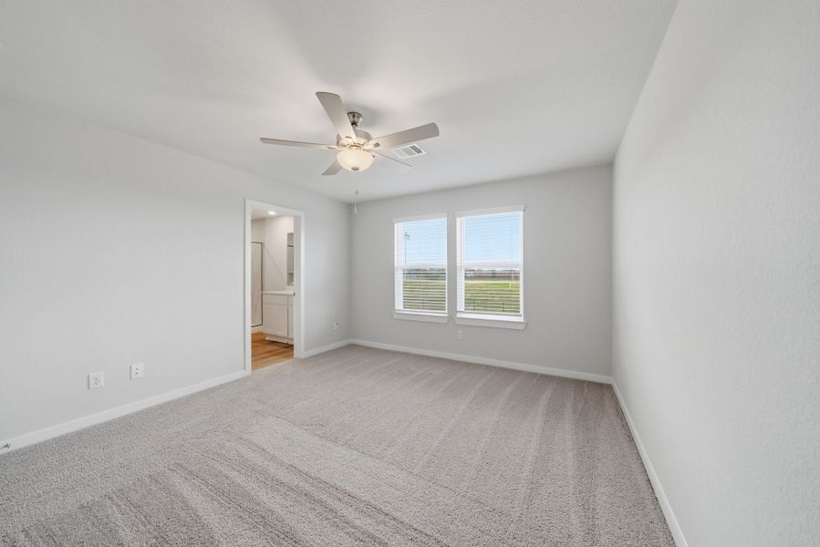 A room with a ceiling fan and a carpet. A room with a ceiling fan and a carpet.