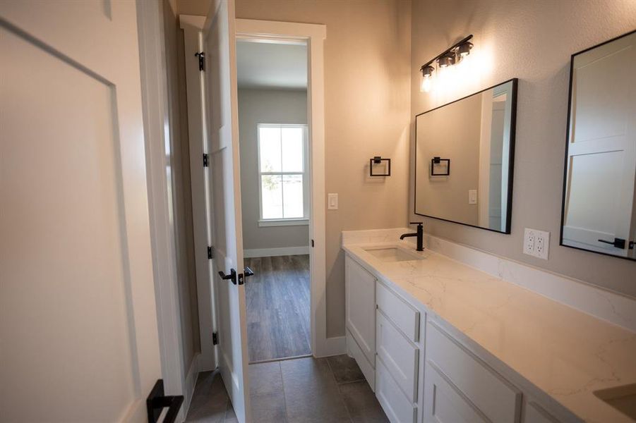 Bathroom featuring vanity and dark tile patterned flooring Bathroom featuring vanity and dark tile patterned flooring