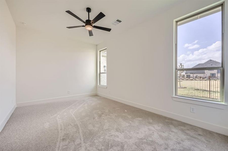 Carpeted empty room featuring ceiling fan