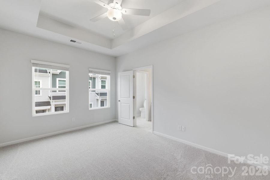 Primary Bedroom with 10' Tray Ceiling Primary Bedroom with 10' Tray Ceiling
