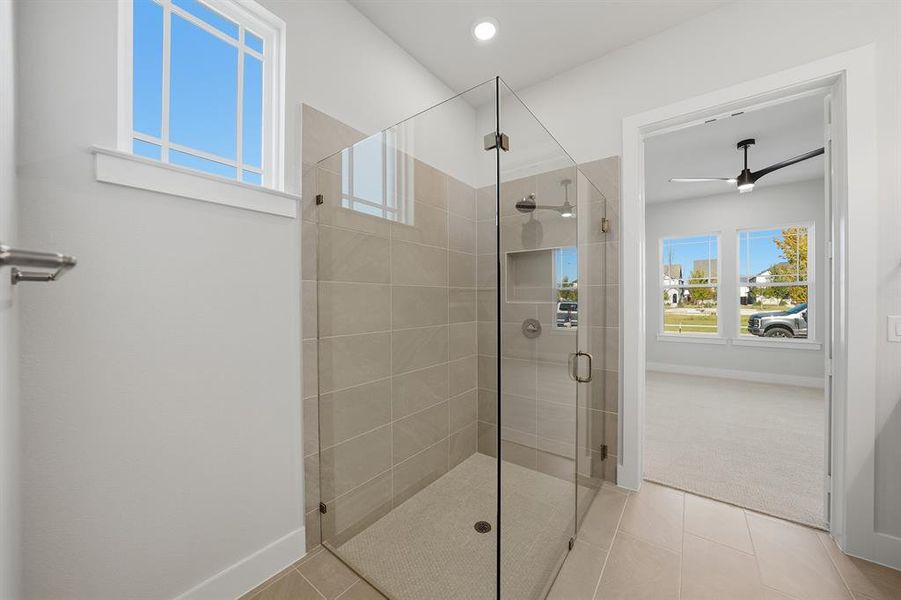 Bathroom featuring a shower stall, tile patterned floors, ceiling fan, and carpet floors