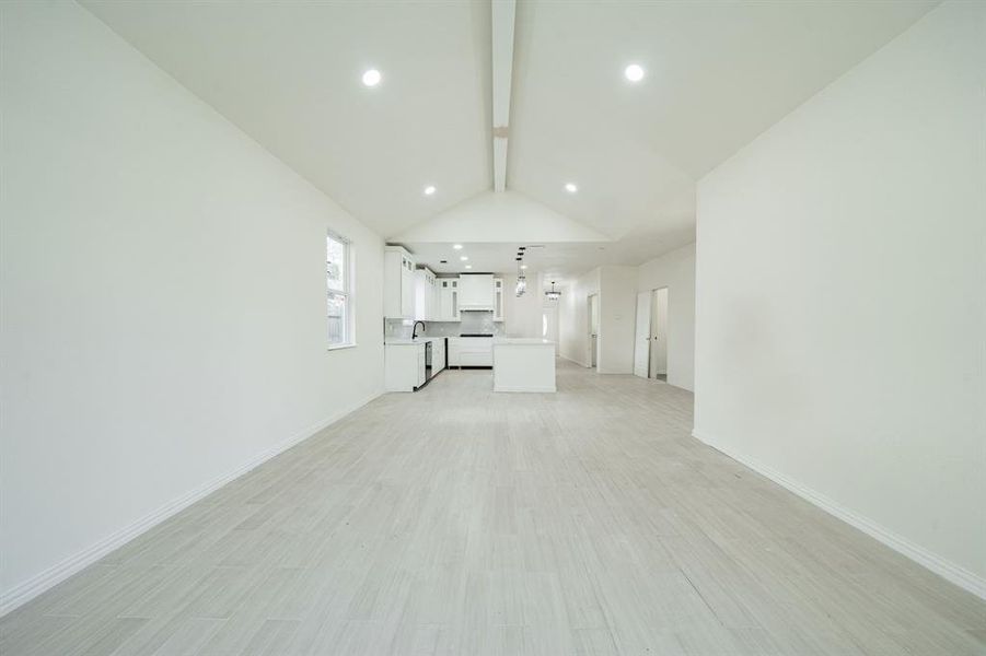 Unfurnished living room featuring light wood-tile flooring and recessed lighting