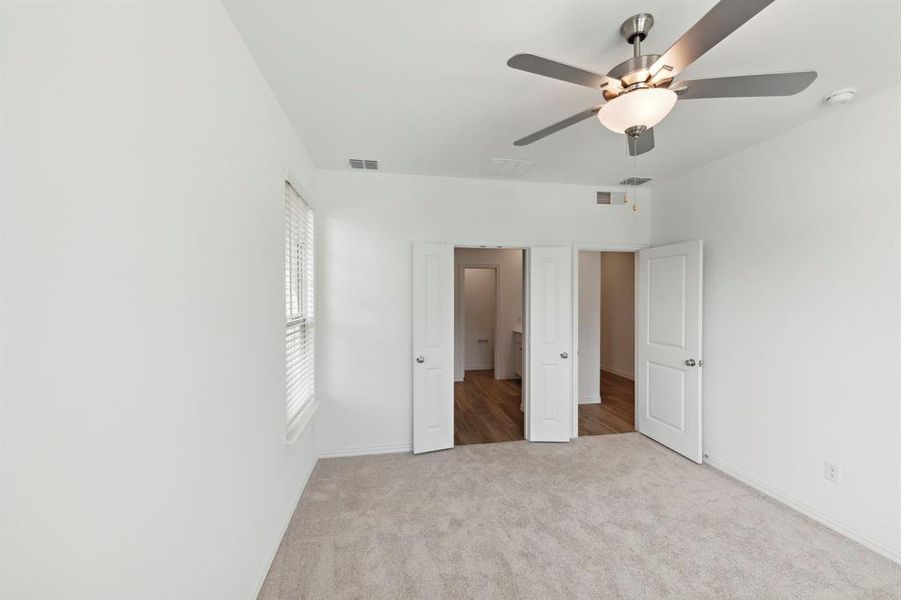 Unfurnished bedroom featuring ceiling fan and light carpet