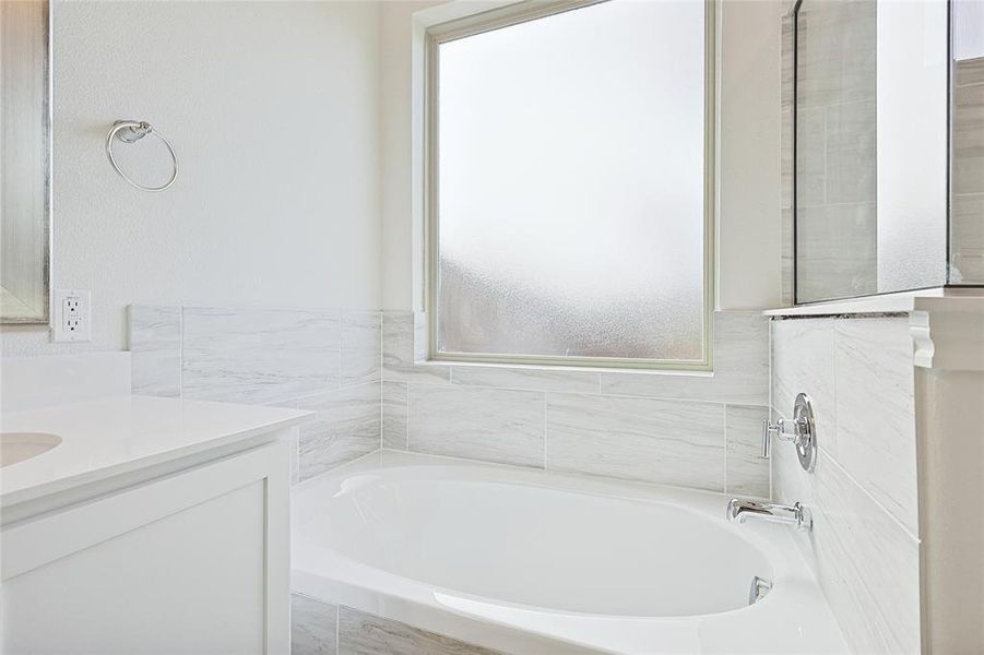 Bathroom featuring a bath and vanity