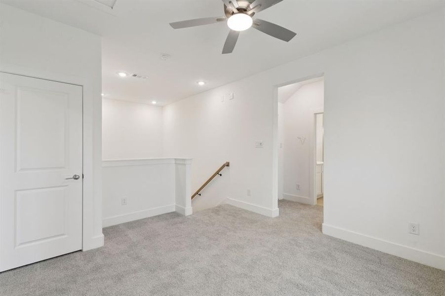 Unfurnished room featuring light colored carpet and ceiling fan Unfurnished room featuring light colored carpet and ceiling fan