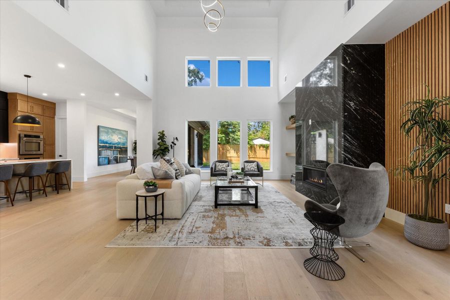 This spacious living room featureshigh ceilings and large windows,offering abundant natural light. Itboasts a modern design with astriking black granite fireplace, and lightwood flooring creating awelcoming and elegant atmosphere. This spacious living room featureshigh ceilings and large windows,offering abundant natural light. Itboasts a modern design with astriking black granite fireplace, and lightwood flooring creating awelcoming and elegant atmosphere.